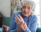 Seniorka s revmatoidní artritidou na rukou